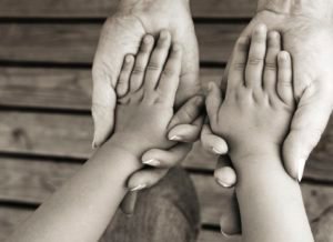 Adult's hands holding child's hands, mature adult, child aged 2 to 3 years